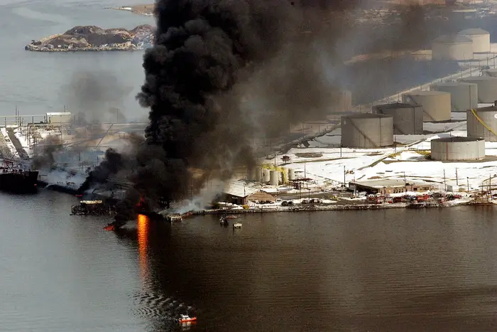 Smoke and flames rise from an explosion at an oil storage refinery February 21, 2003 in the Staten Island